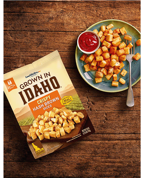 Plate of hash brown dices on wooden table.