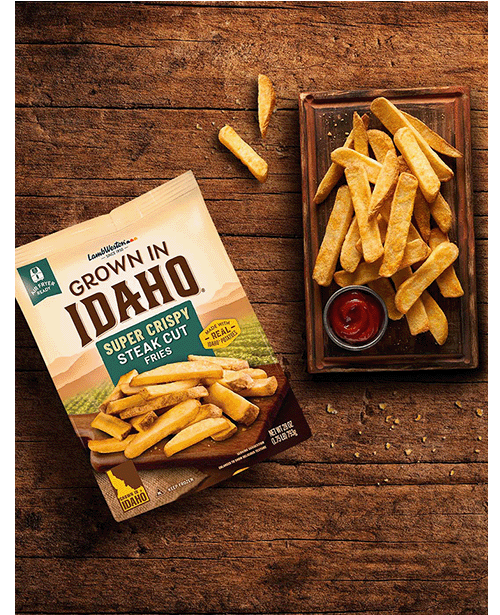 Plate of steak cut fries on wooden table.