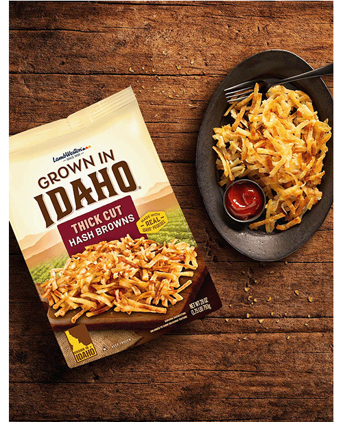 Plate of thick cut hash browns on wooden table.