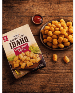 Plate of tots on wooden table.